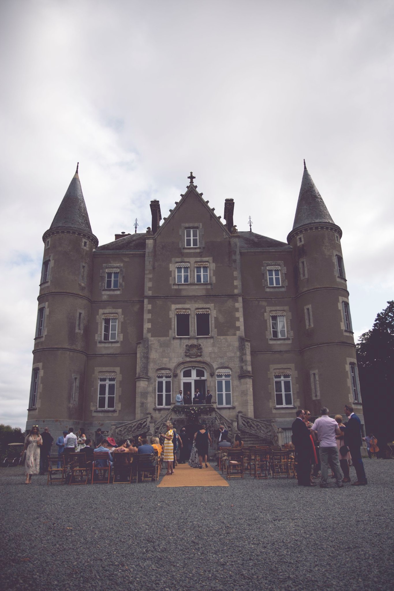 Image of a Chateau with wedding guests waiting out the front for wedding to start